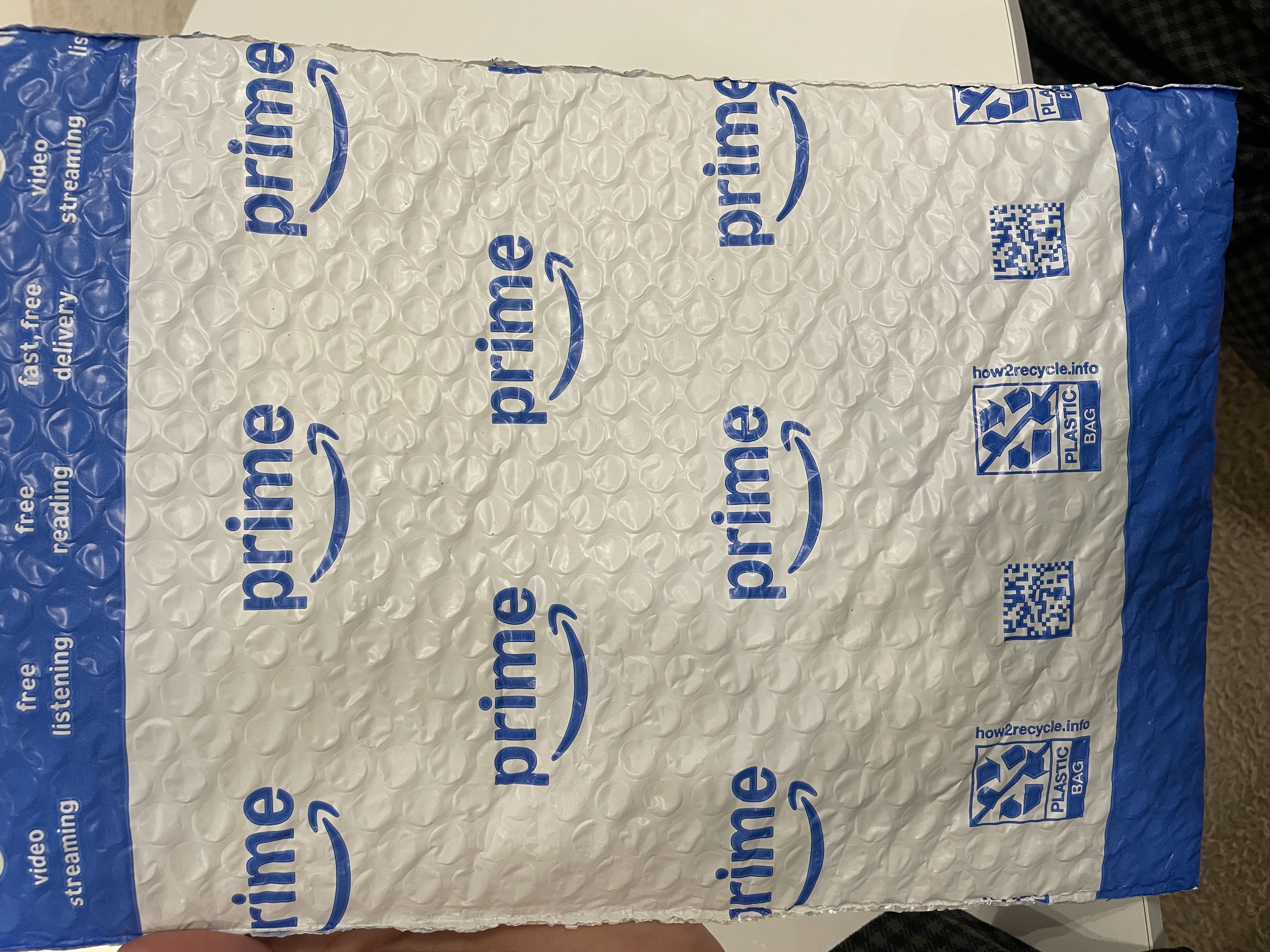 Amazon Prime 버블 메일러 외부 — "prime" 로고가 반복 인쇄된 흰/파란 봉투